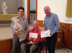 Sur la photo, on aperçoit le vice-président de l'ARLPH, M. Alain Bélanger, entouré de MM. Joshua Ménard-Suarez et Jocelyn Landry, représentants de la Bibliothèques de Montmagny, tenant le certificat honorifique et le panier de produits régionaux remportés.